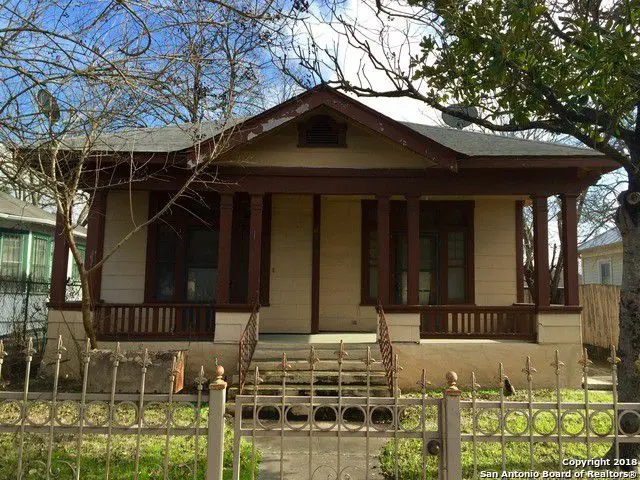 a small house with a fence in front of it