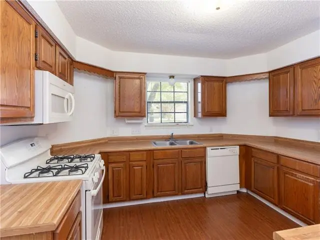 a kitchen with wooden cabinets and white appliances