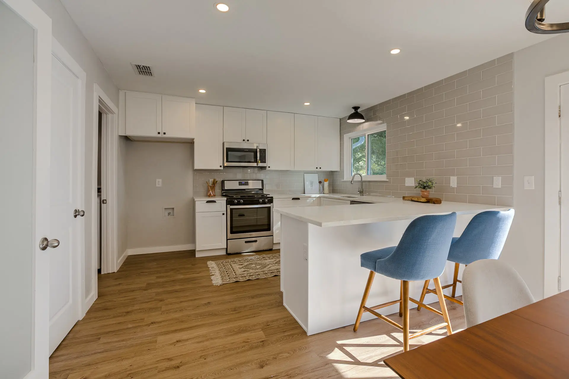 a kitchen with a center island with blue chairs