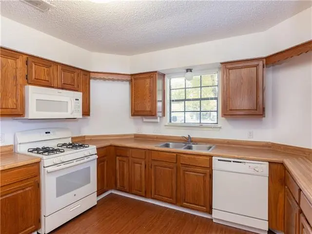a kitchen with wooden cabinets and white appliances