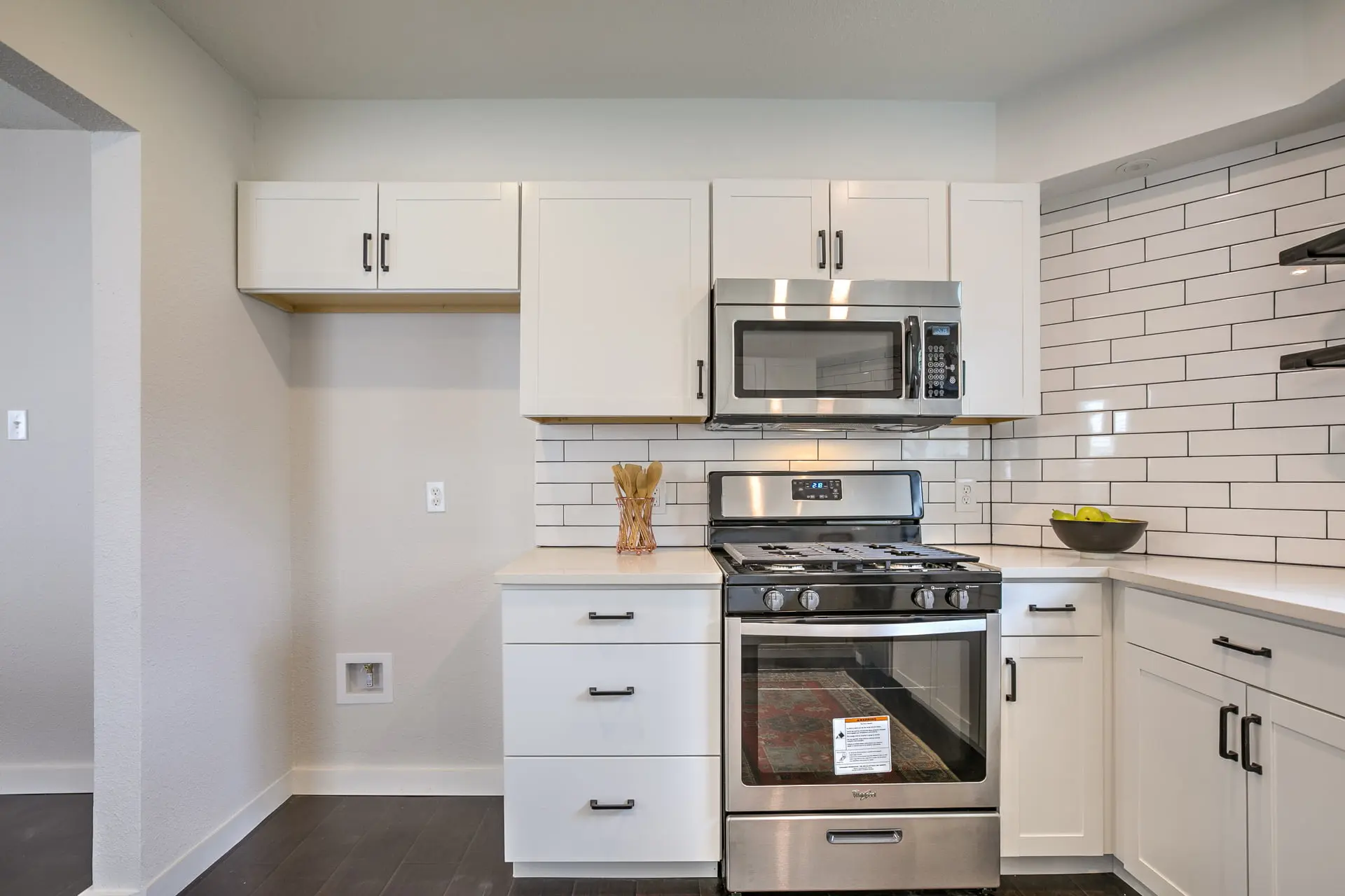 a kitchen with white cabinets and stainless steel appliances