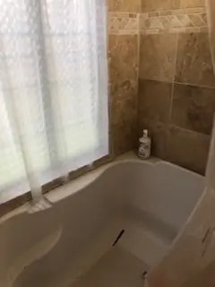 a bathroom with a bathtub and a shower curtain