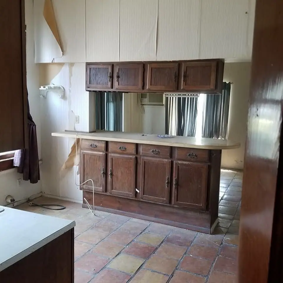 a kitchen with a sink, cabinets and a window