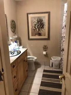 a bathroom with a toilet, sink, and mirror