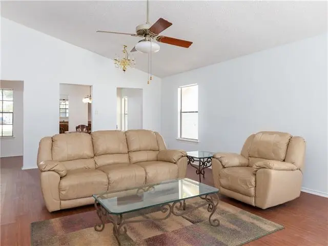 a living room filled with furniture and a ceiling fan