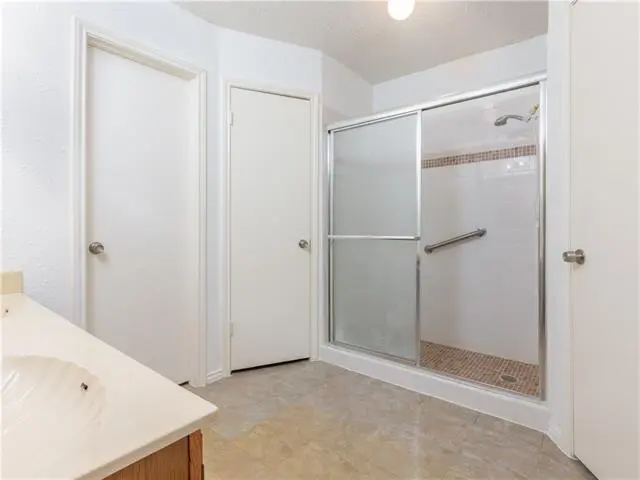 a bathroom with a walk in shower next to a sink