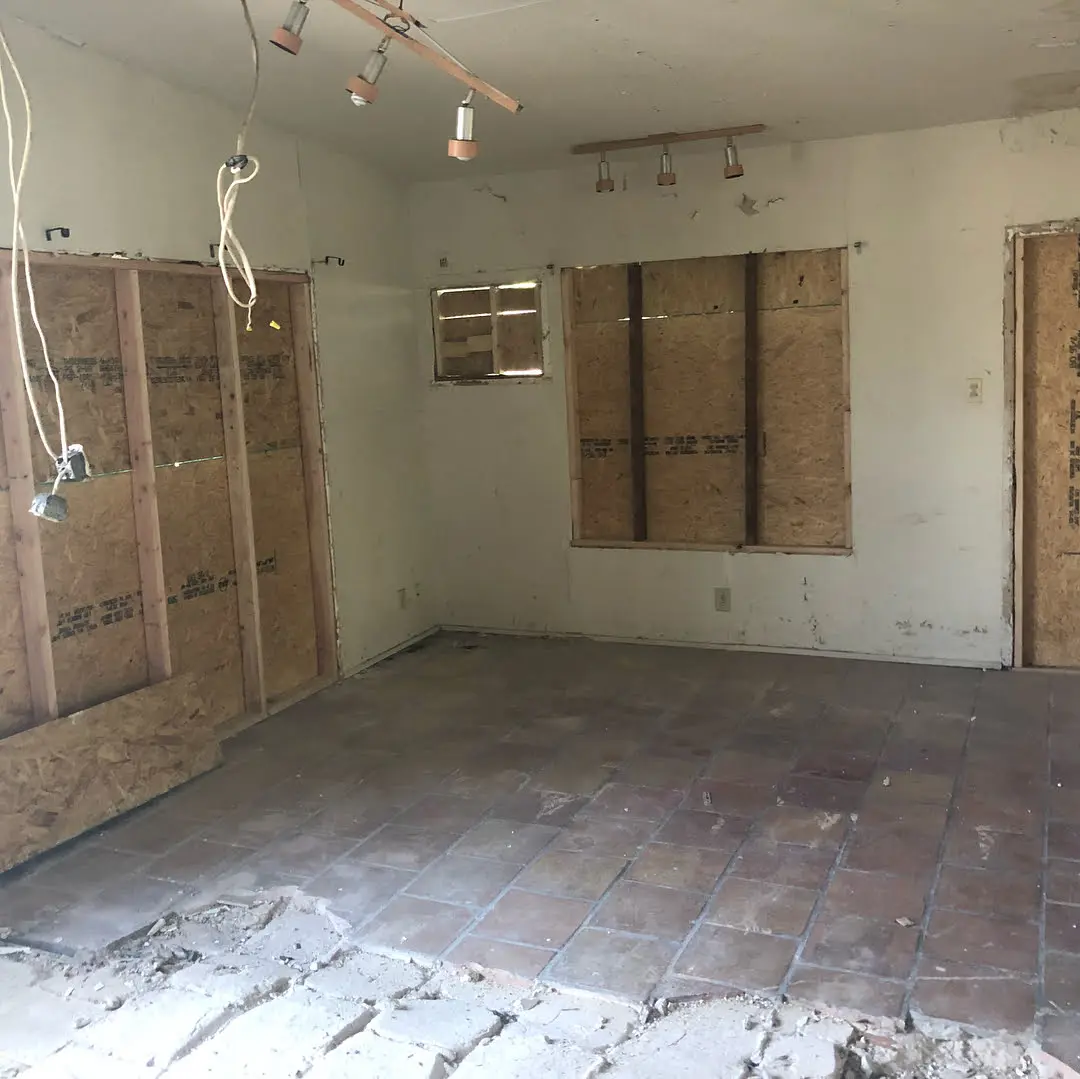 an empty room with wooden doors and a brick floor