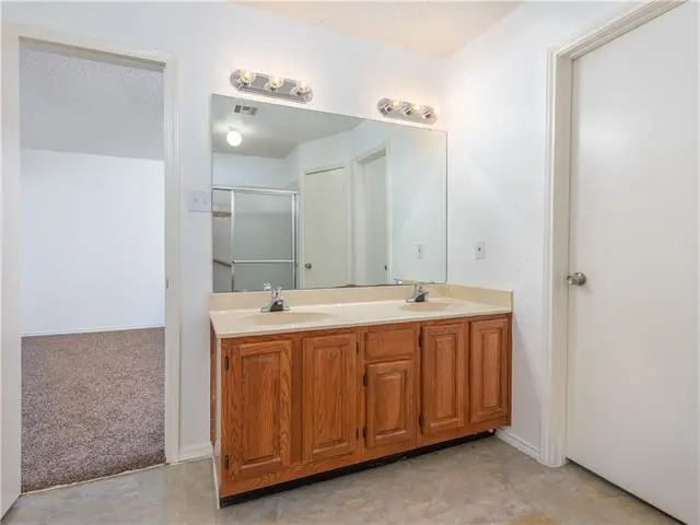 a bathroom with a double sink and a large mirror