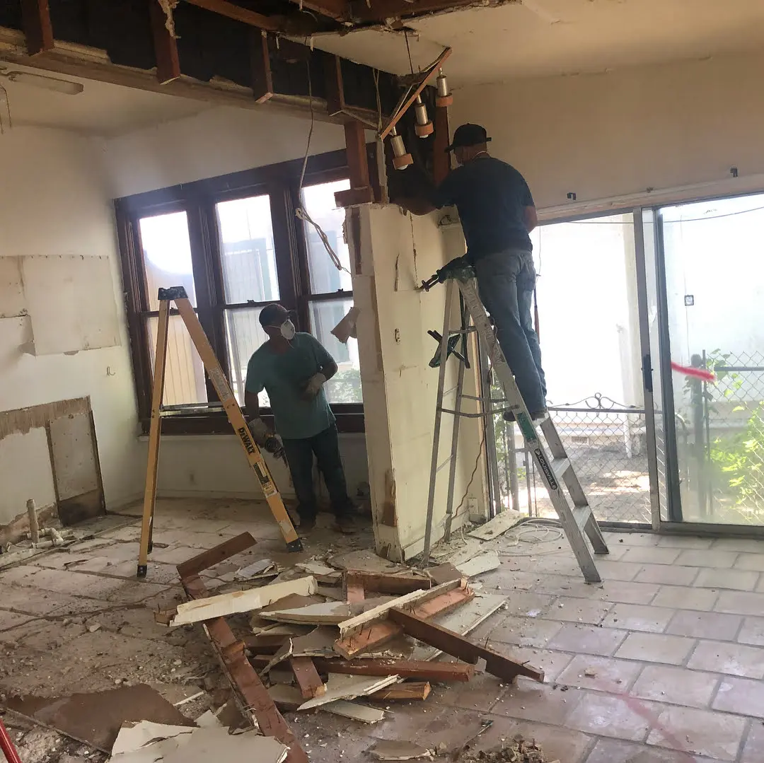 a couple of men standing on top of a ladder