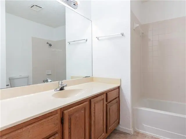a bathroom with a sink, mirror and bathtub