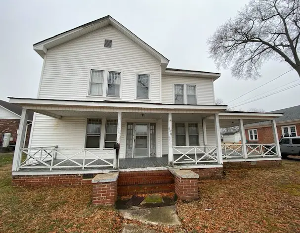 a white two story house with a porch