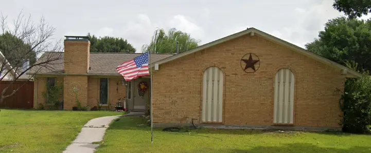 a brick house with a flag in front of it