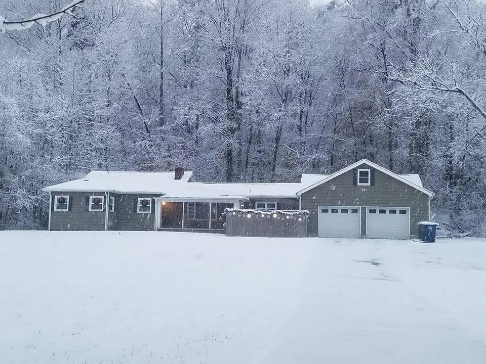 a house in the middle of a snow covered field