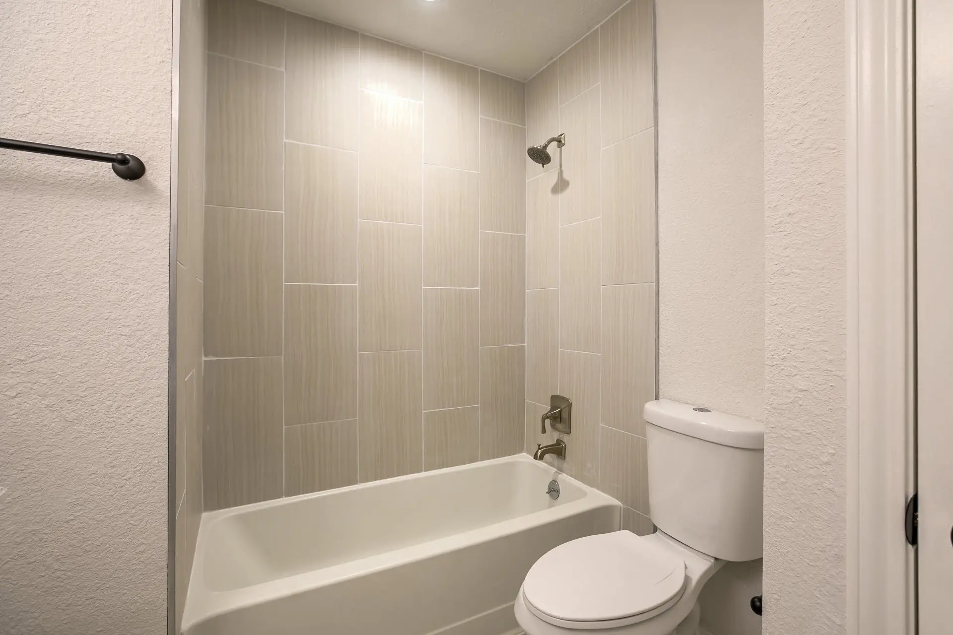 a white toilet sitting next to a bath tub