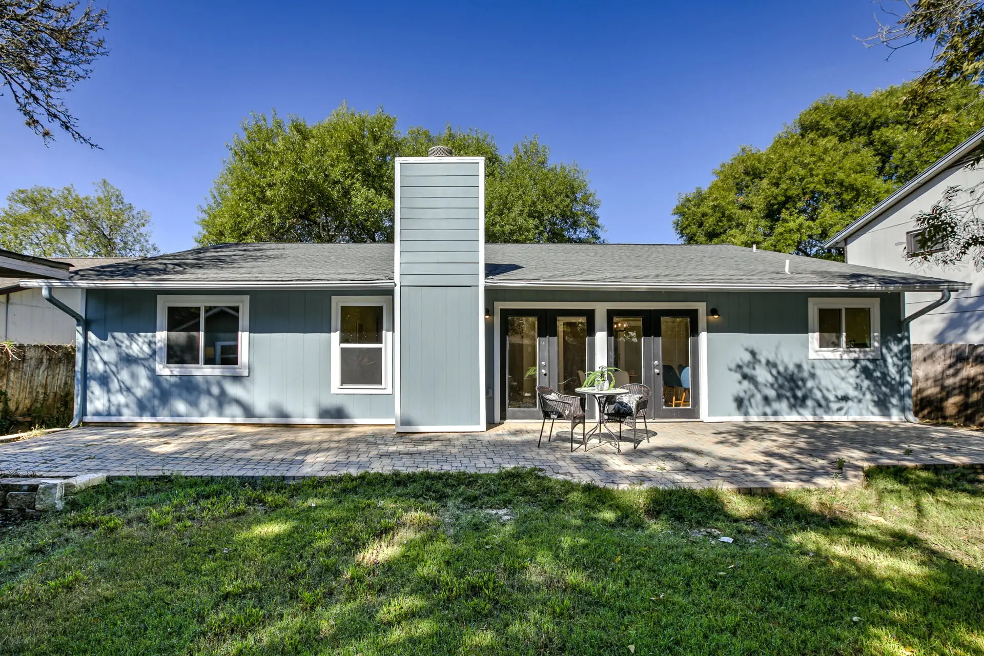 a blue house with a patio in the front yard