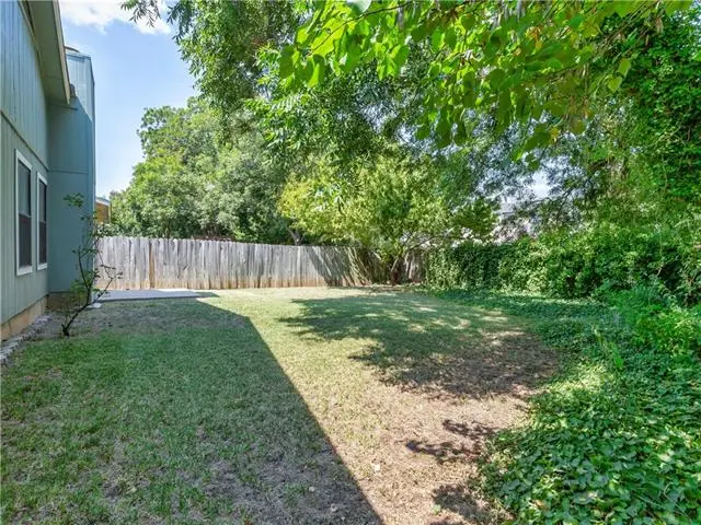 a back yard with a fence and trees