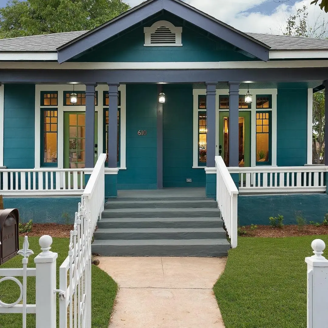 a blue house with a white picket fence