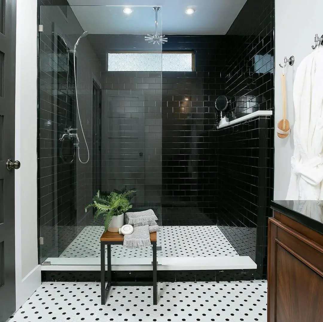 a black and white tiled bathroom with a walk in shower