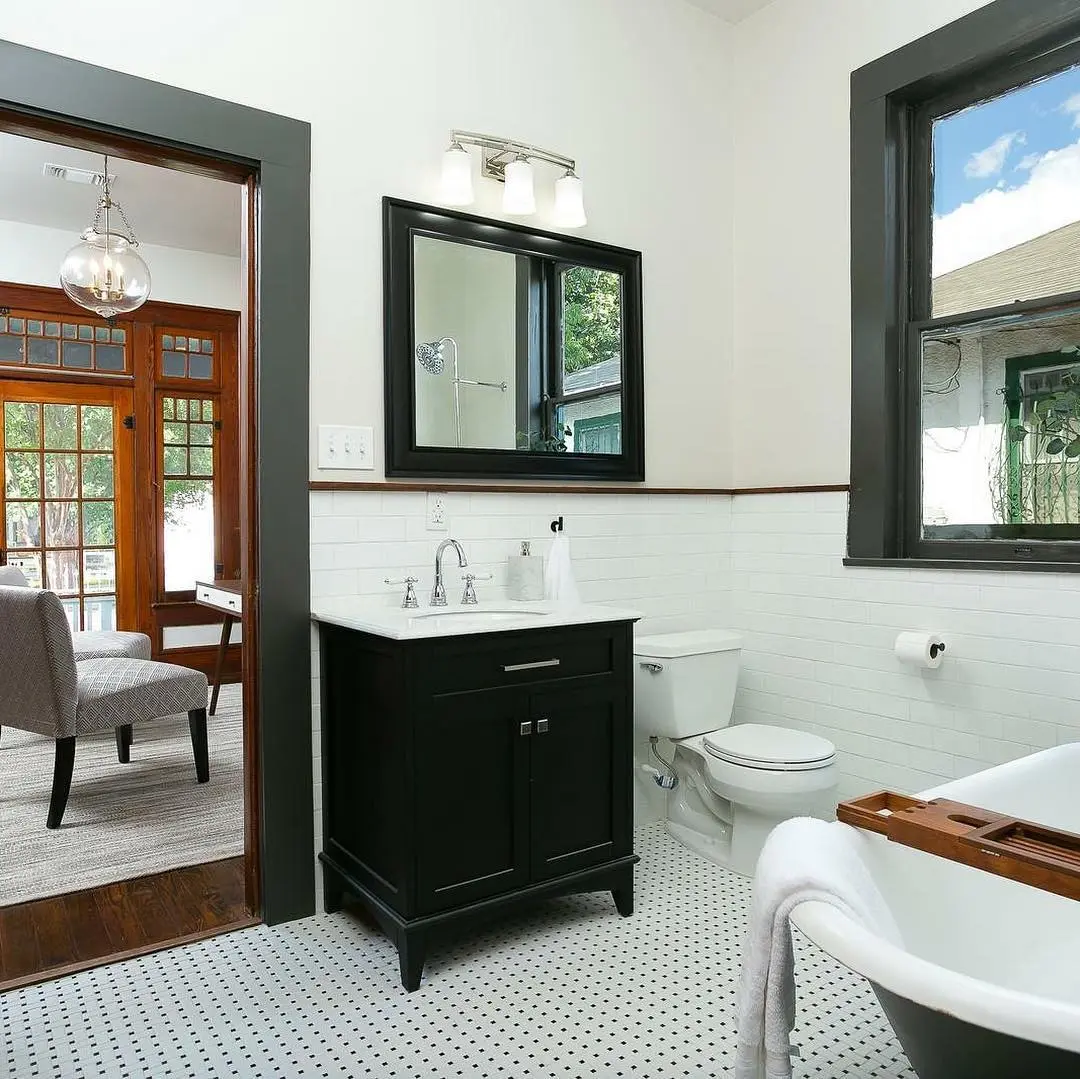 a bathroom with a tub, sink, toilet and mirror