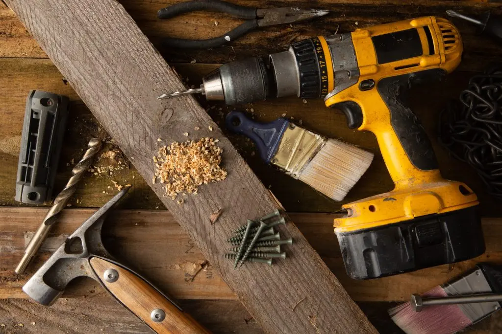 various tools and hardware laying on wooden floor