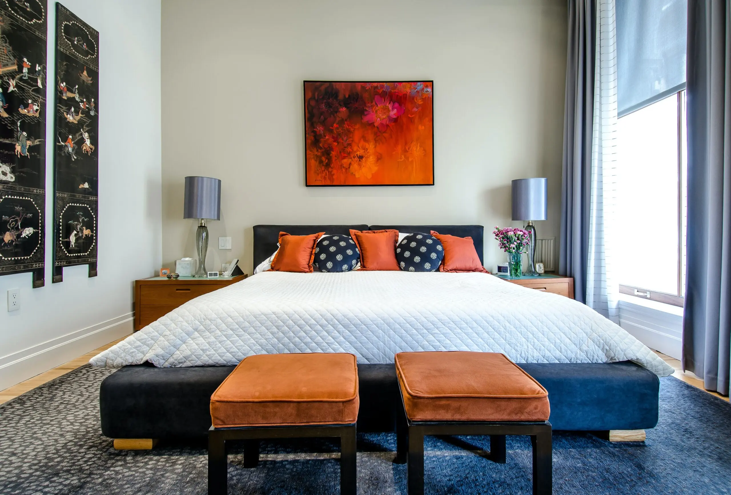 a bedroom with a painting on the wall above the bed