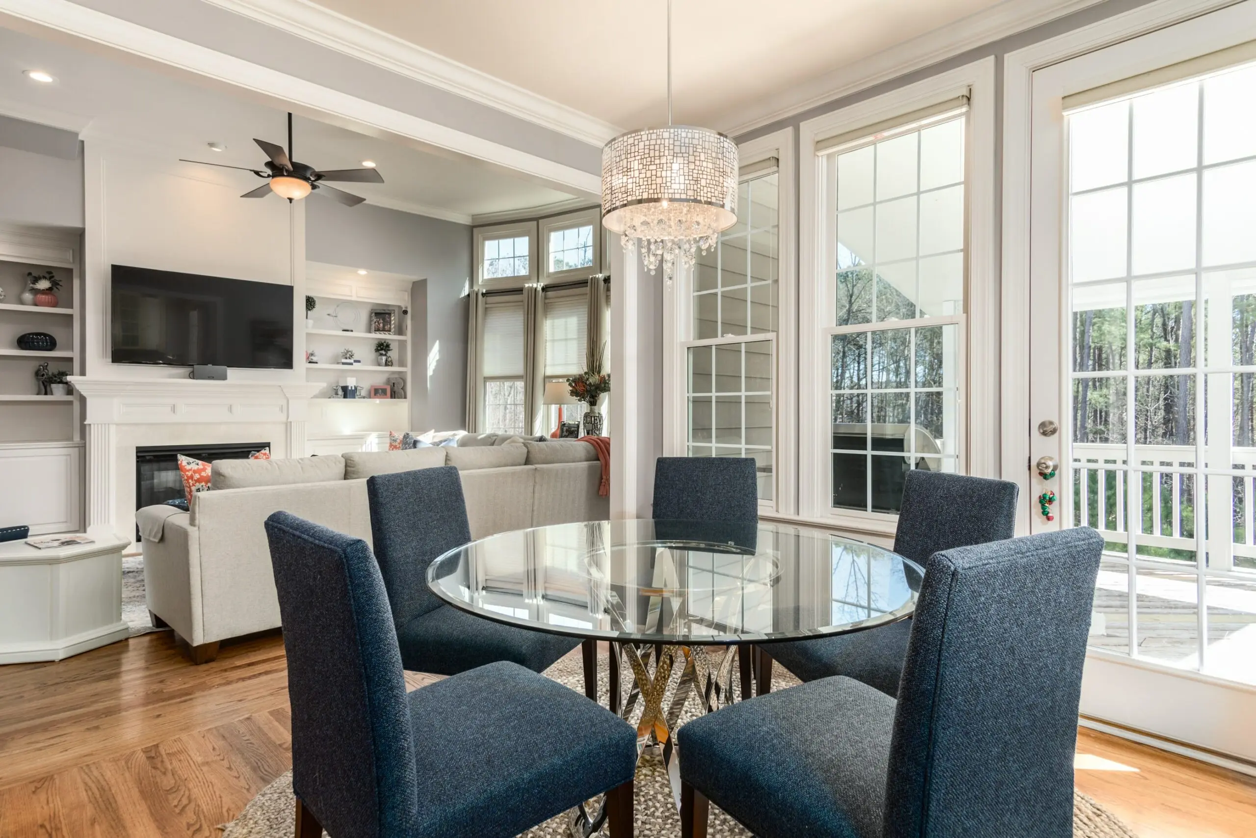 a dining room with a round glass table and blue chairs