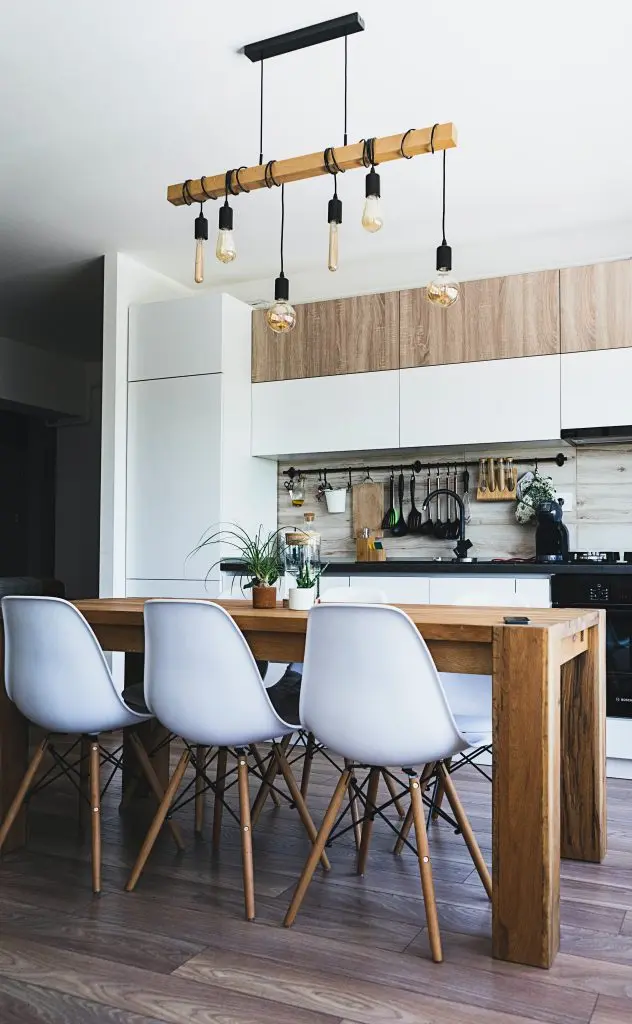 a kitchen with a wooden table and white chairs