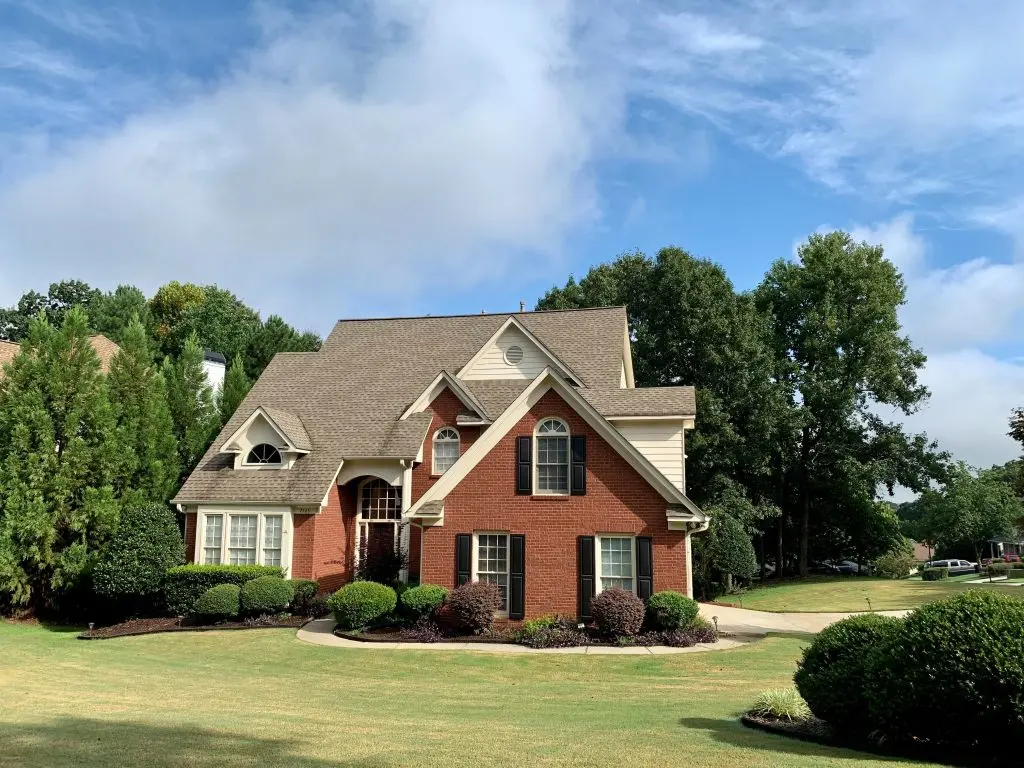 a red brick house with white trim and black shutters