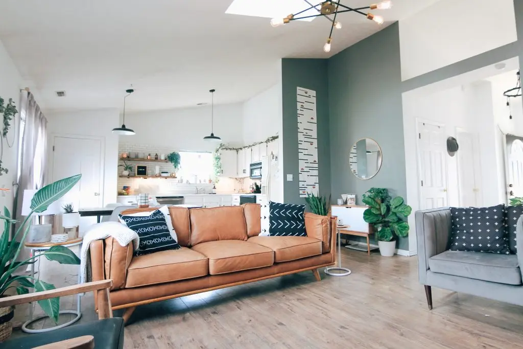 a living room with a brown couch and black and white pillows