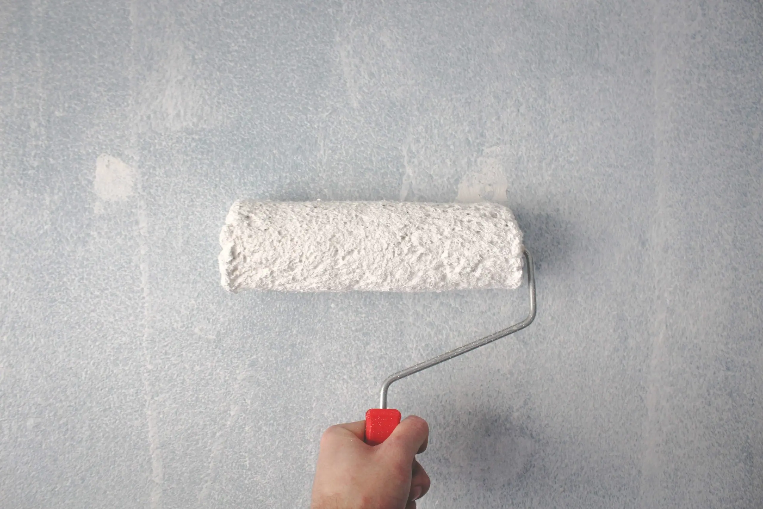 https://www.newwestern.com/wp-content/uploads/2023/01/person-holding-paint-roller-on-wall-1669754-1-scaled-1.jpg