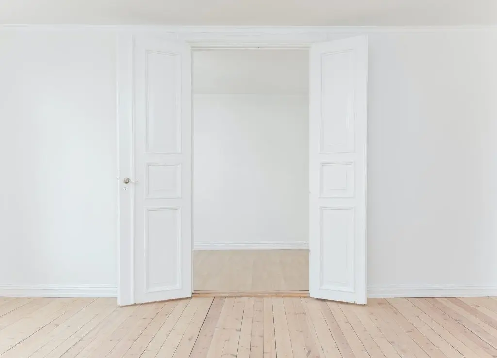 an empty room with white walls and wooden floors