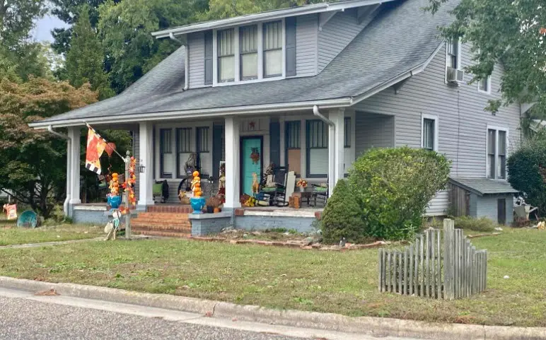 a gray house with people standing outside of it