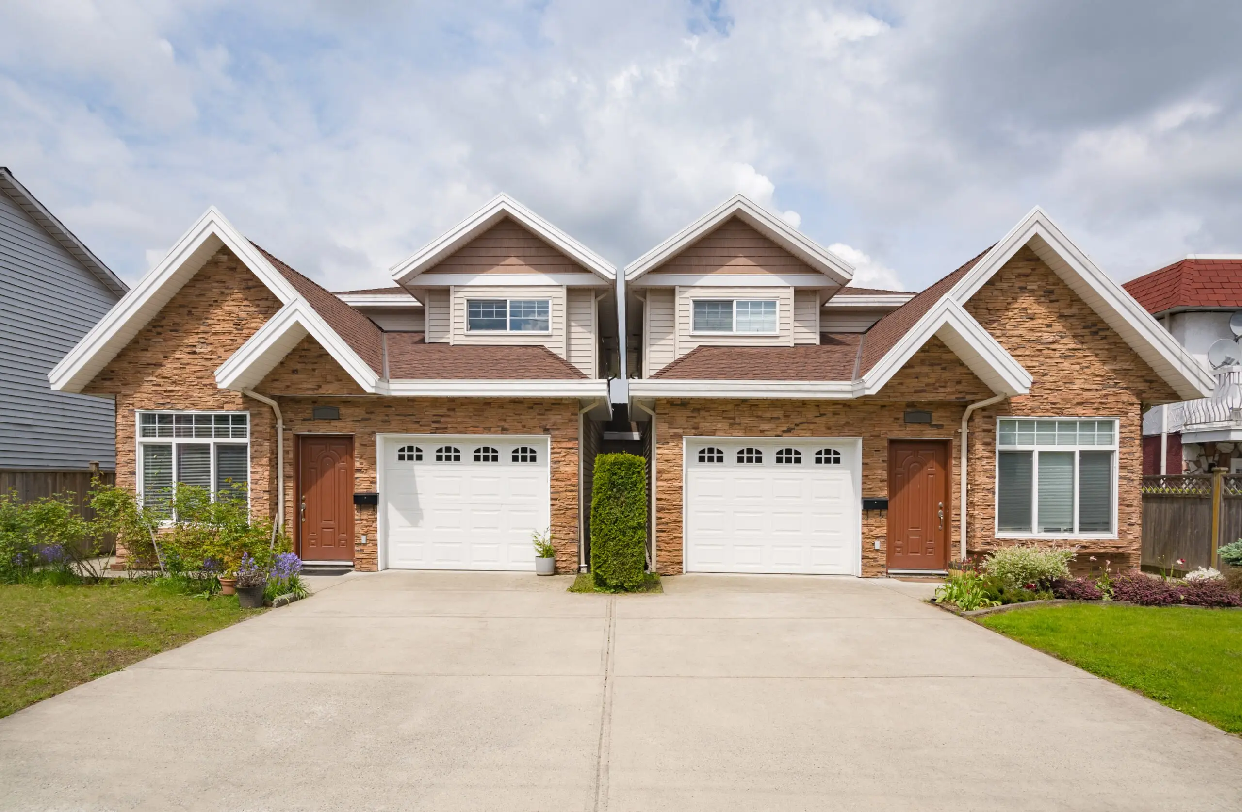 brick duplex with white garage doors