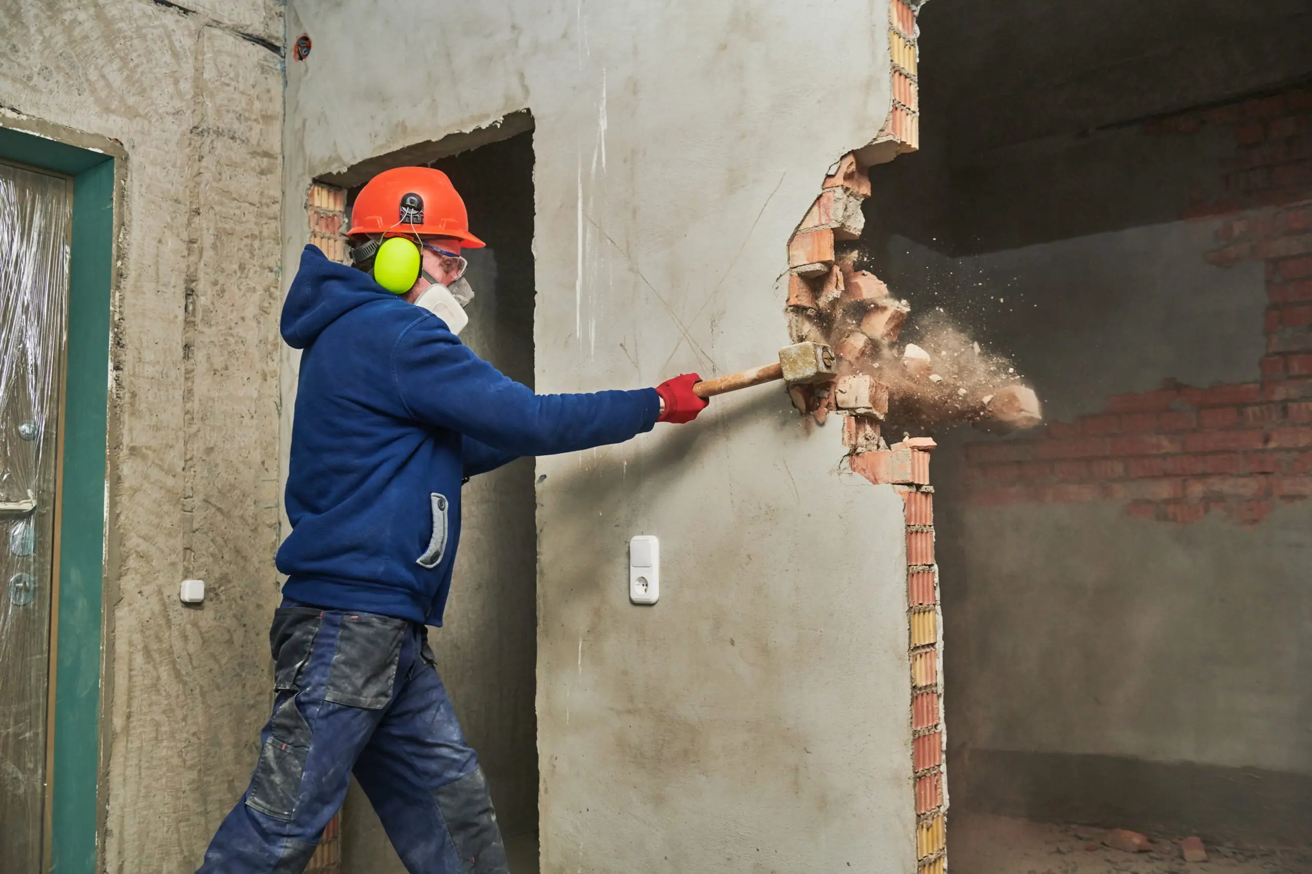 a man knocking down a wall