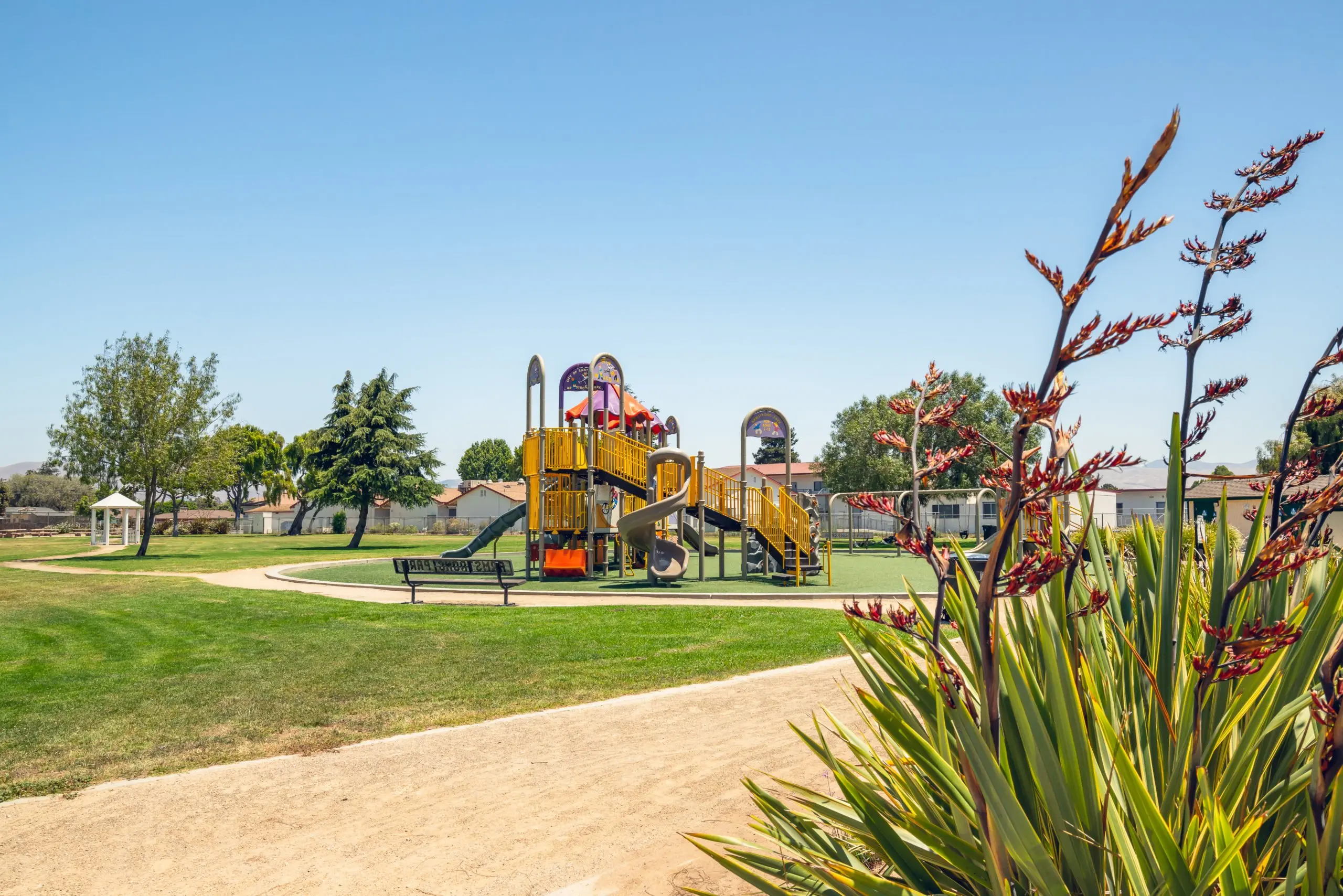 a playground in a park with flowers in the foreground