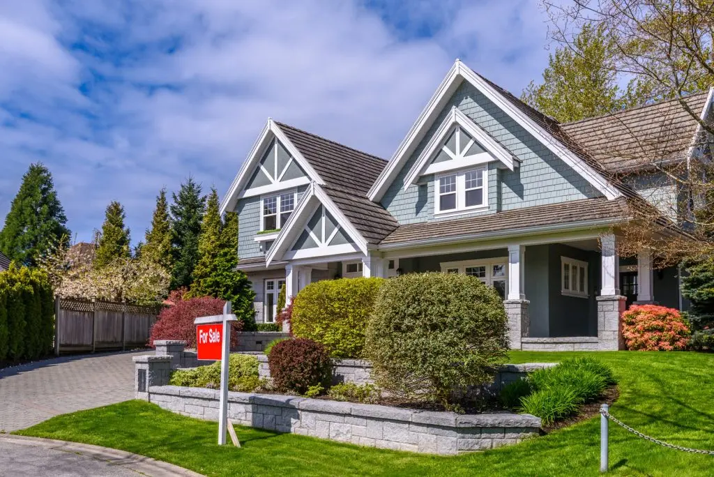 a house with a for sale sign in front of it