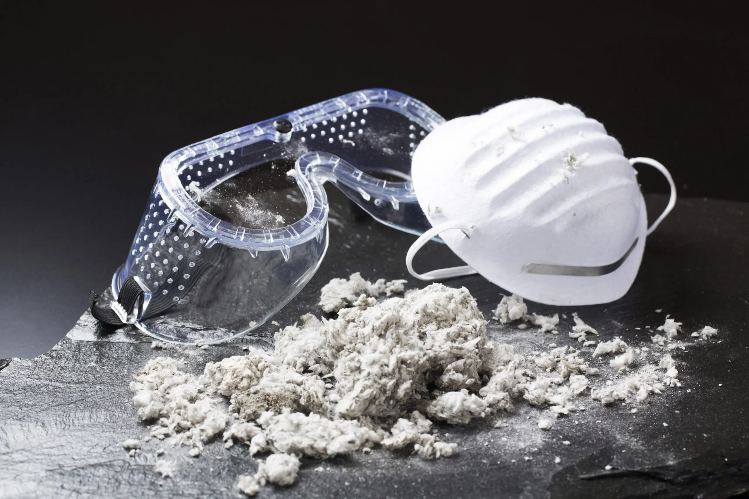 a pair of goggles a mask and a pile of dust