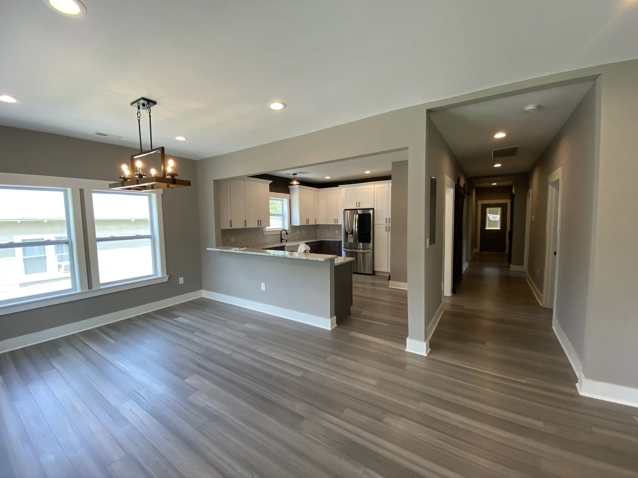 a large empty living room with wood floors