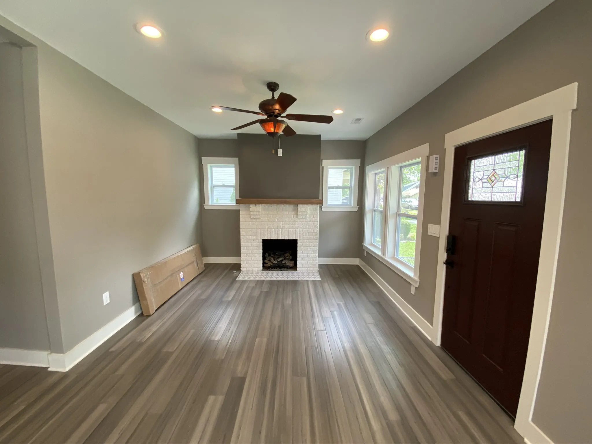 a living room with a fireplace and a ceiling fan