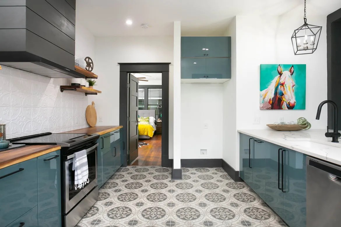 a kitchen with a tile floor and blue cabinets