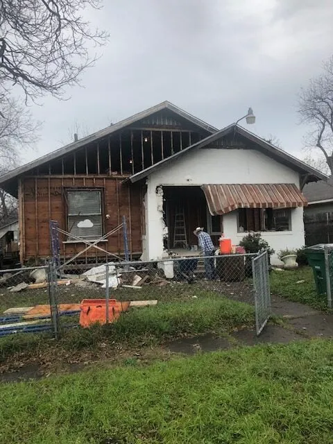 a house that is under construction with a fence in front of it