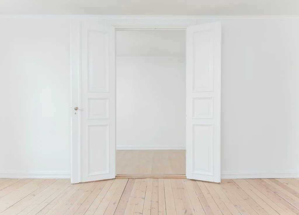 an empty room with white walls and wooden floors