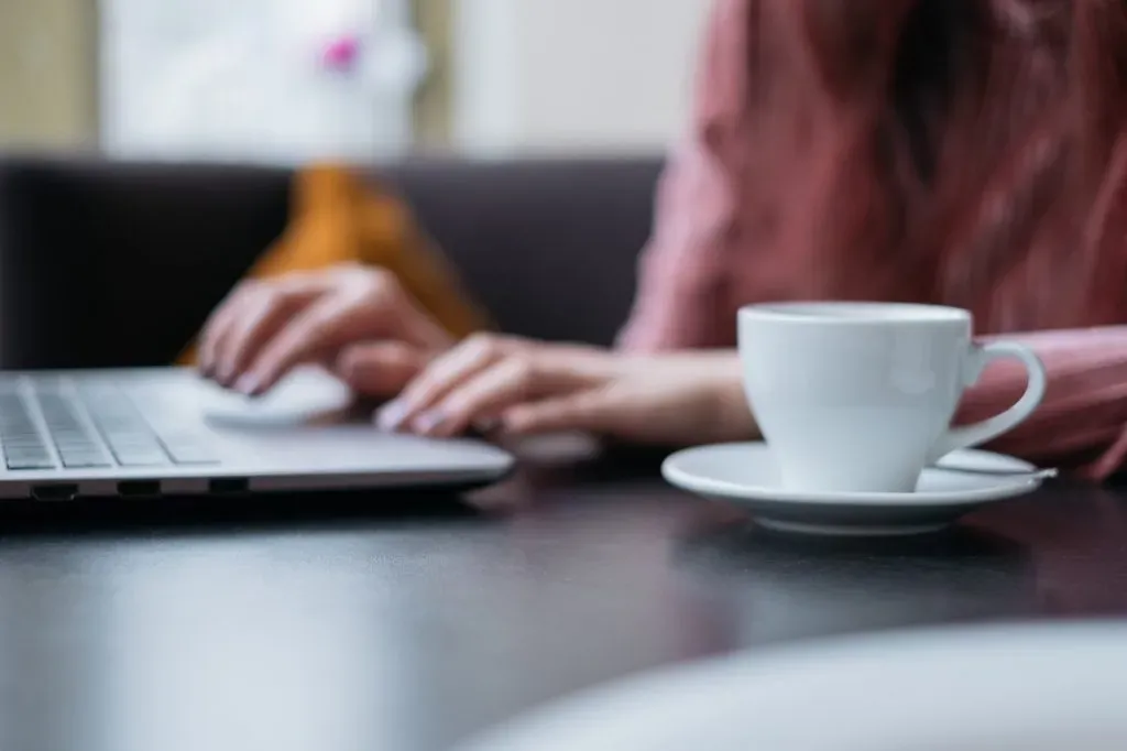 female working on a laptop in a cafe
