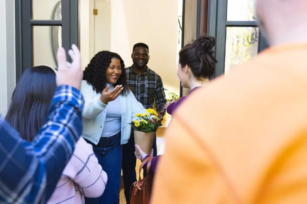 couple happily receiving guests into their home